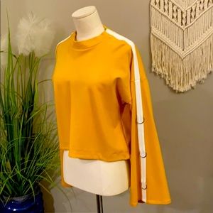Mustard top with metal hoops on sleeves